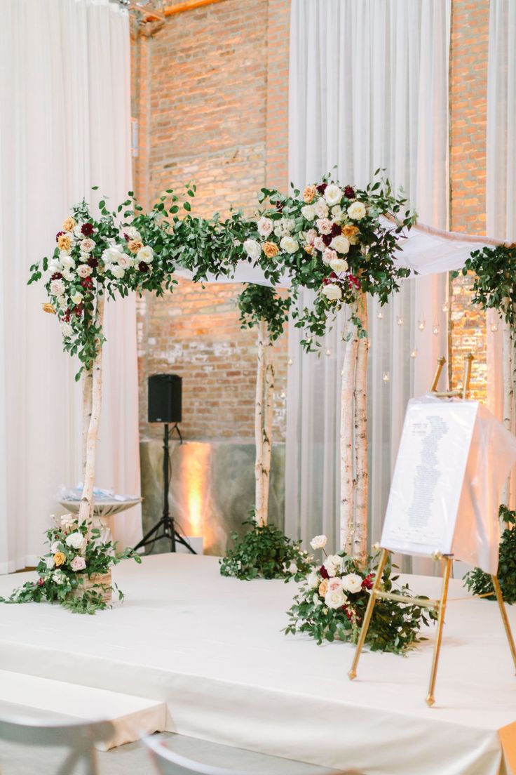 a white table topped with flowers and greenery