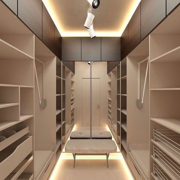 an empty walk in closet filled with lots of white shelves and shelving unit lights