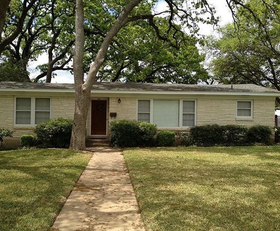 a house with trees and grass in front of it