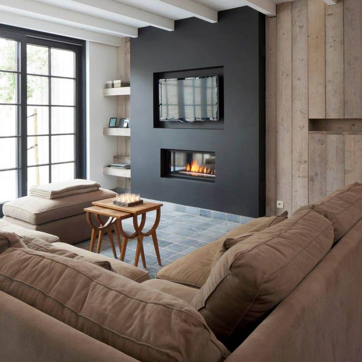 a living room filled with furniture and a fire place in the middle of the room