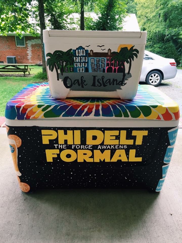 a cooler sitting on top of a sidewalk next to a park bench with the words phi delt formal written on it