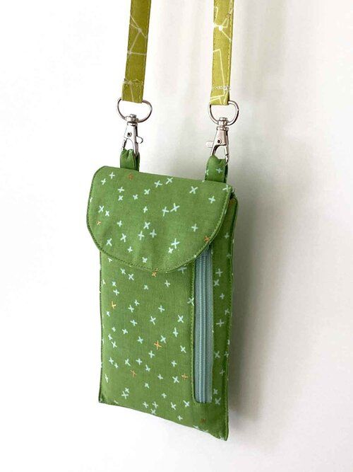 a small green bag hanging from the side of a wall with two straps attached to it