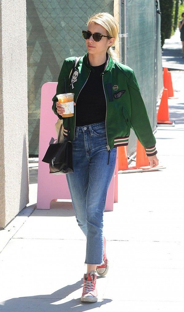 a woman walking down the street with a cup in her hand