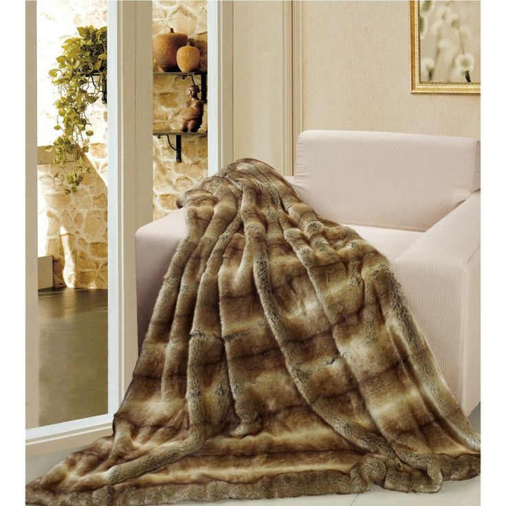 a large brown and white fur blanket on top of a couch