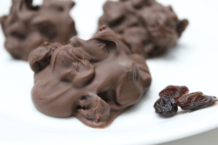 three pieces of chocolate on a plate with raisins