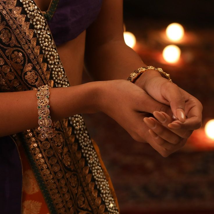 Description Crafted for festive events, this antique gold-plated silver bangle is expertly encrusted with Kempu stones on a traditional Indian temple & peacock ensemble. The perfect companion to festive attire the shine of the gold tone along with the Goddess Lakshmi motif makes it irresistible and regal. Style with a necklace set from the Mandira collection for a grand look. Product Information Metal: 925 Silver with 1.0 microns Antique Gold Plating Length: 6(2.6) cm Stones: Semi-precious stone Gold Temple Jewelry With Hand Set Details, Elegant Bangle For Navratri, Elegant Hand Set Traditional Wear For Diwali, Traditional Festive Hand Set Chandbalis, Traditional Festive Chandbalis With Hand Set Details, Festive Traditional Hand-set Chandbalis, Elegant Bangle For Diwali Celebration, Ceremonial Gold Chandbalis With Peacock Design, Gold Chandbalis With Peacock Design For Ceremonial Events