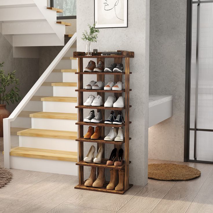 there is a shoe rack on the wall next to some stairs and a potted plant