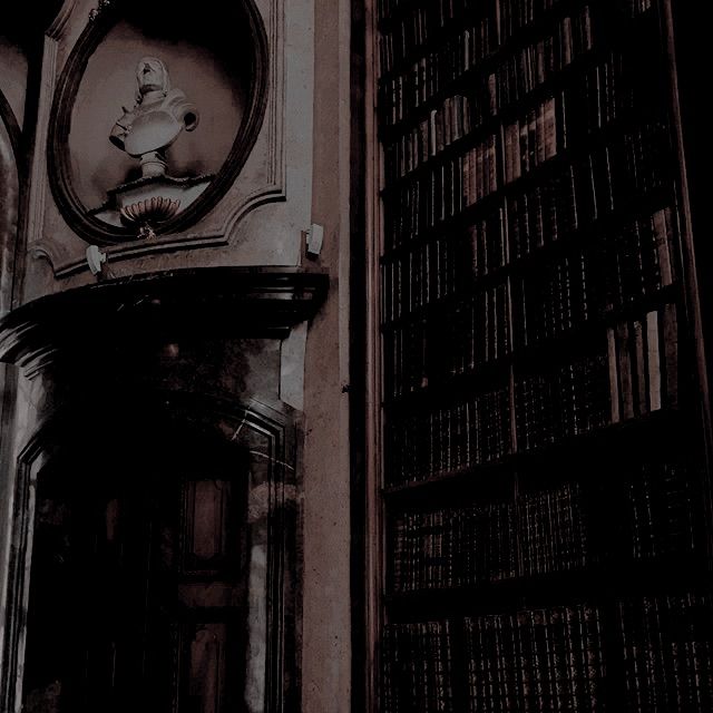 an old clock on the side of a building with bookshelves in the background