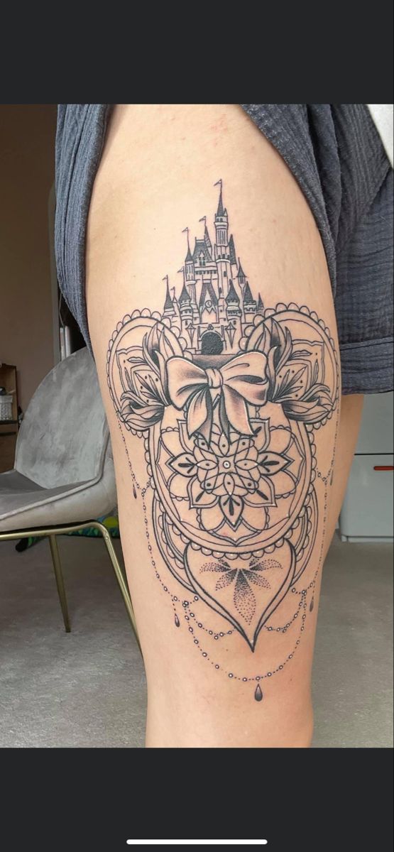 a woman's leg with a tattoo on it and a castle in the background