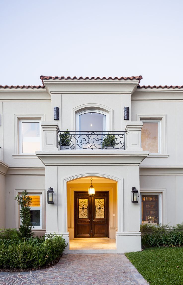 a large white house with an entry way leading to the front door and side entrance