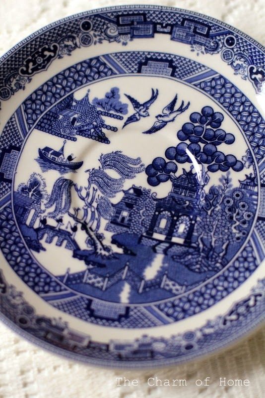 a blue and white plate sitting on top of a table next to a cloth covered floor