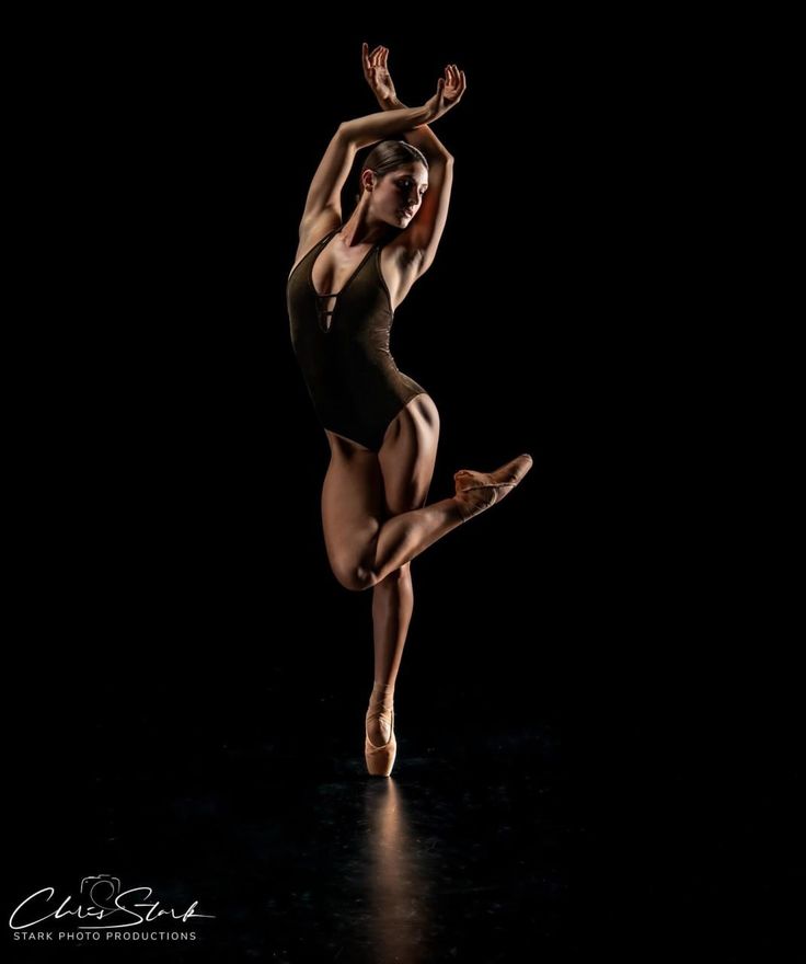 a woman in black leotard and ballet shoes is doing a dance pose with her legs spread out