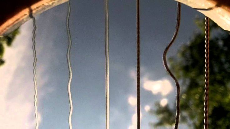 the reflection of trees and clouds is shown in this circular window pane, as seen from below