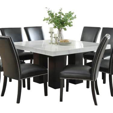 a white marble dining table with black leather chairs