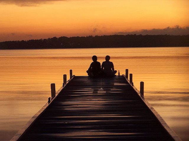 two people sitting on a dock with the quote women marry men hoping they will change