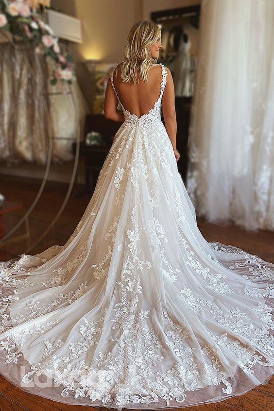 a woman in a wedding dress looking back at the bride's gown on display