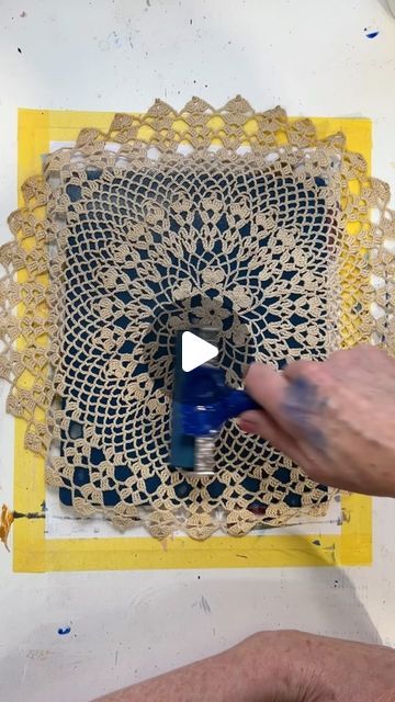 someone is painting an intricate doily with blue paint