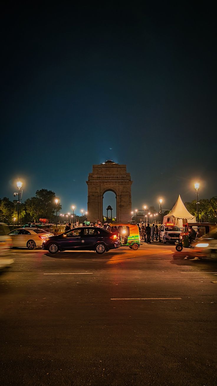 cars are parked in front of the monument at night