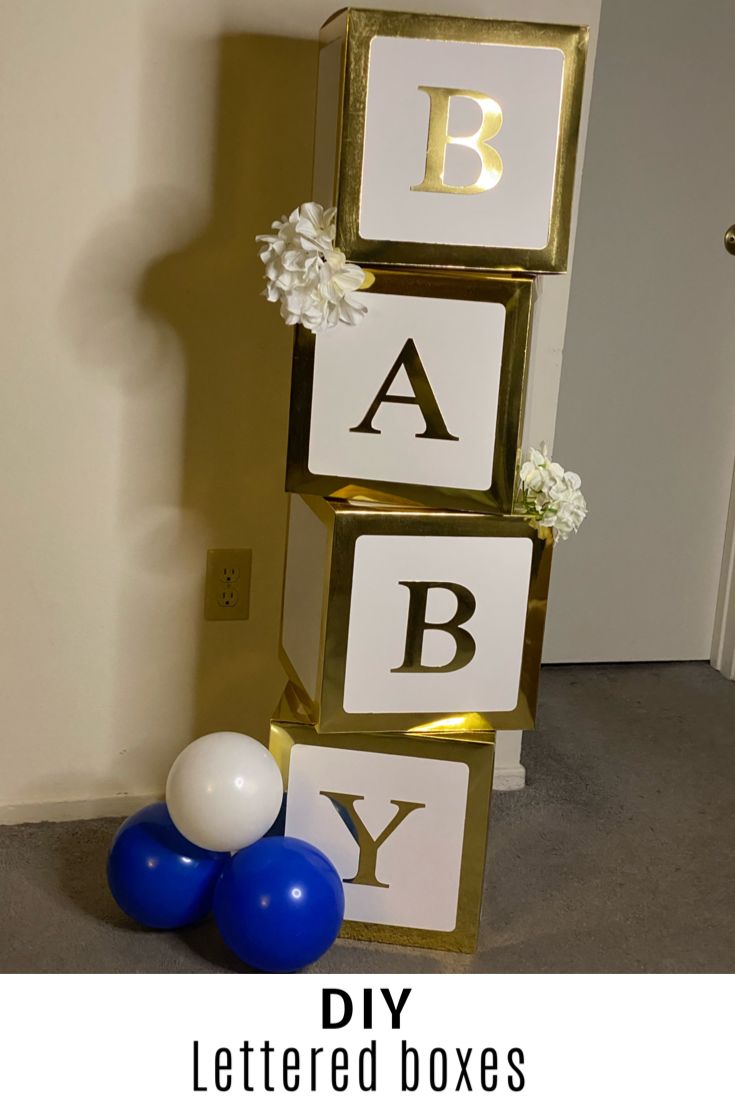 a baby shower sign with balloons on the floor