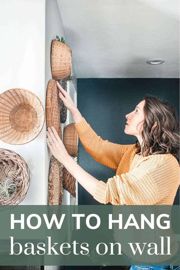 a woman hanging baskets on the wall with text overlay that reads how to hang baskets on walls