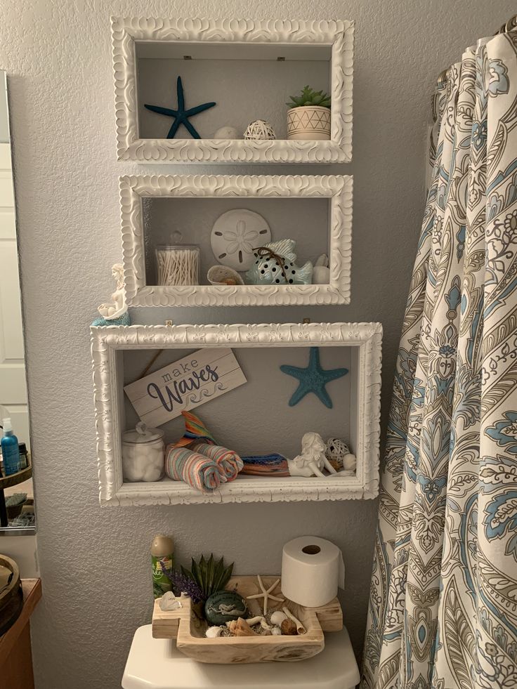 the bathroom is decorated in white and has blue decor on the shelves above the toilet