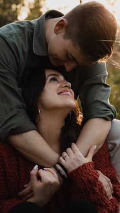 a man and woman embracing each other in the woods