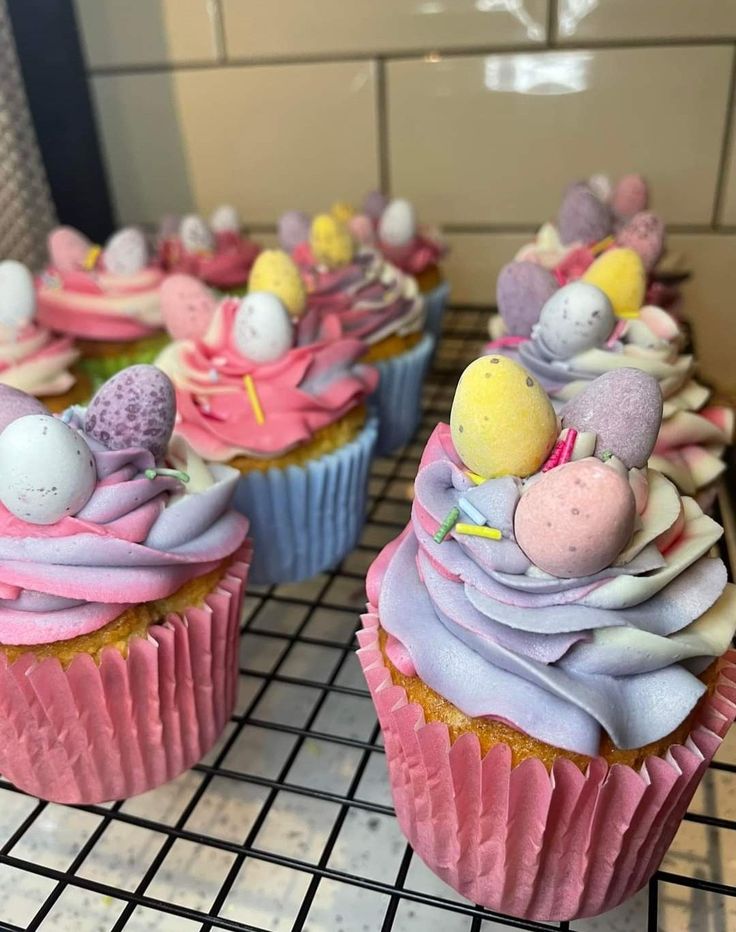 some cupcakes with pink frosting and decorations on them