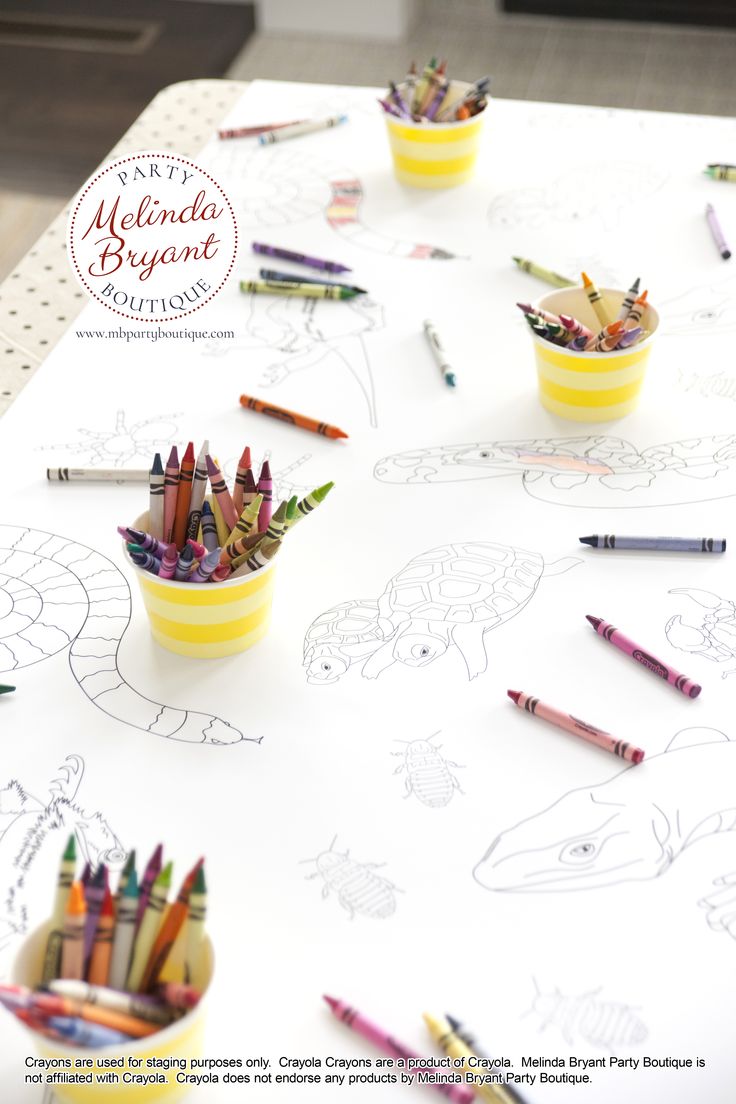 crayons and pencils are sitting in cups on a white table with drawings