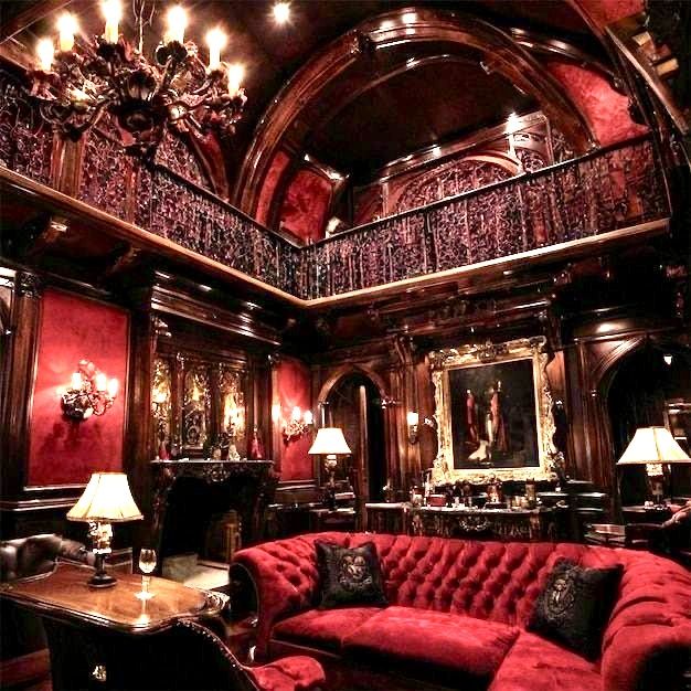 an ornate living room with red couches and chandeliers