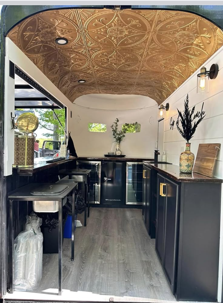 the interior of an rv with wood flooring and black cabinetry is shown in this image