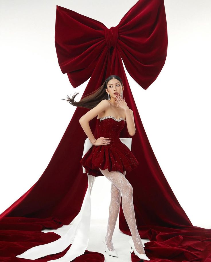 a woman dressed in red and white posing for a photo with her hands on her lips