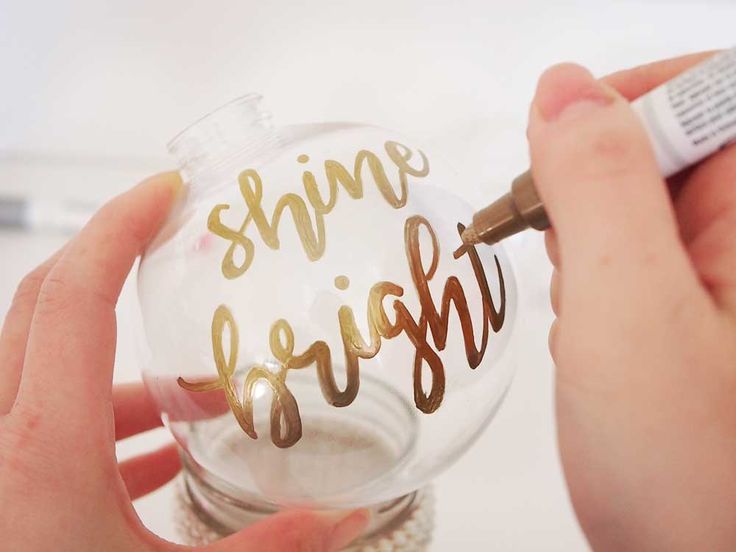 someone is holding a glass ornament with the words shine bright written on it