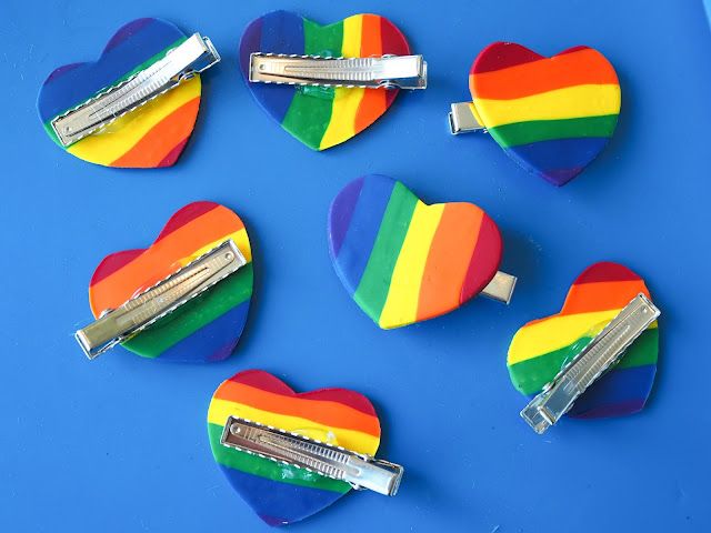 several rainbow heart shaped hair clips on a blue surface