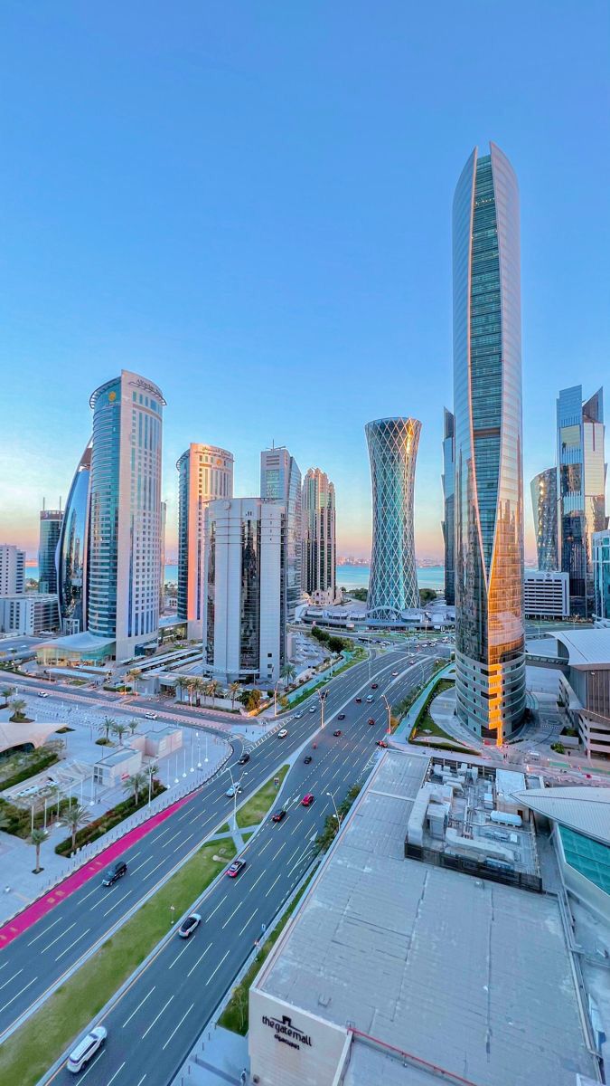 an aerial view of a city with skyscrapers and cars driving on the road in front of it