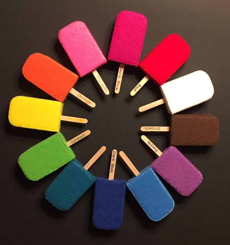 several popsicles are arranged in a circle on a black surface with the colors of rainbow