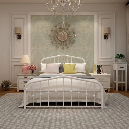 a white bed sitting in a bedroom next to a chandelier