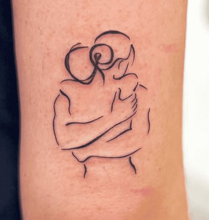 a tattoo on the leg of a person holding a baby