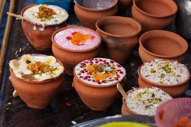 several clay pots filled with different types of food and condiments on top of a table