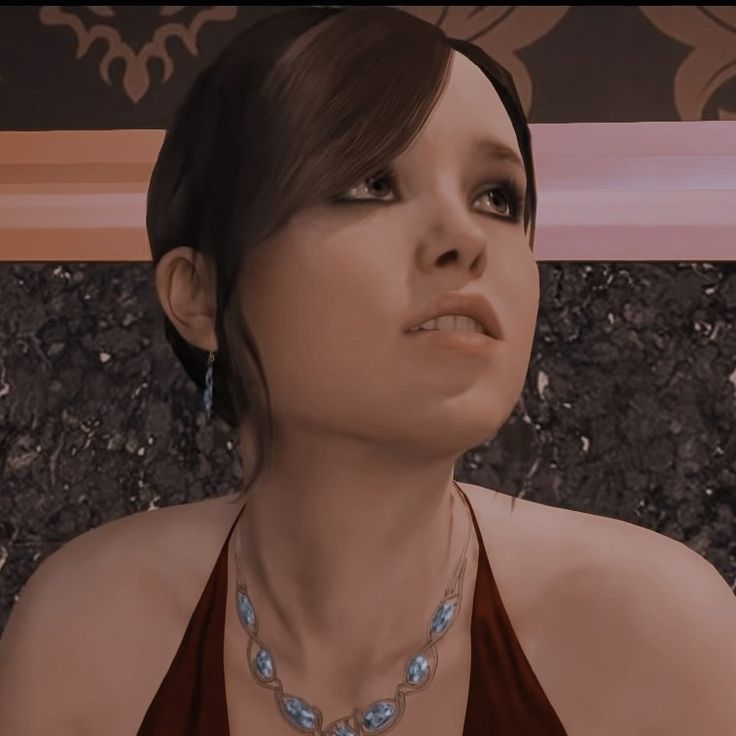 a woman in a brown dress wearing a necklace with blue stones on it's neck