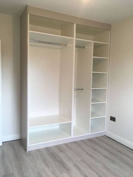 an empty room with white closets and shelves