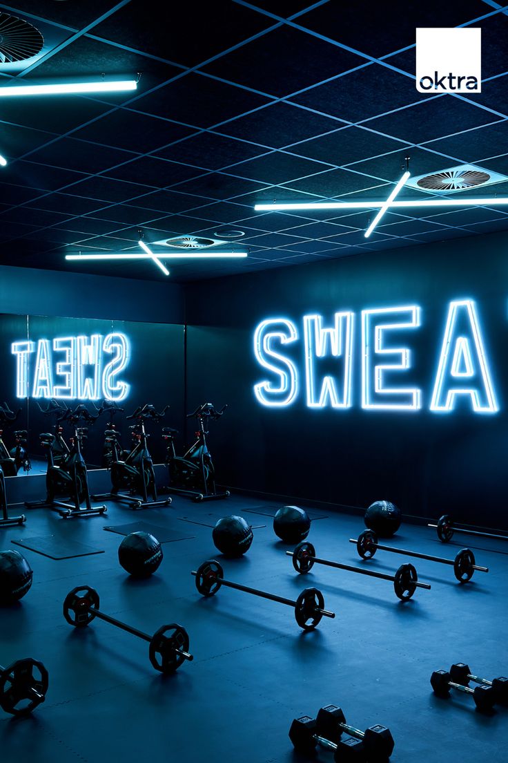 a gym with rows of exercise balls and kettles in front of the word sweat