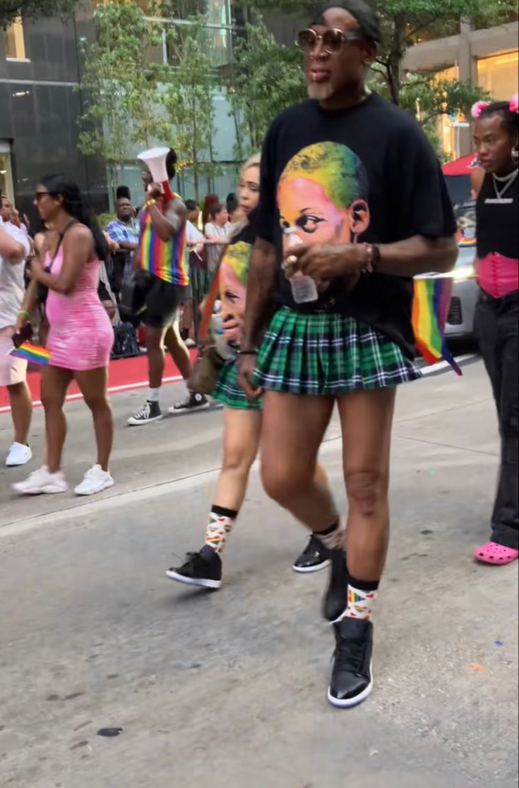 a man is walking down the street wearing a skirt