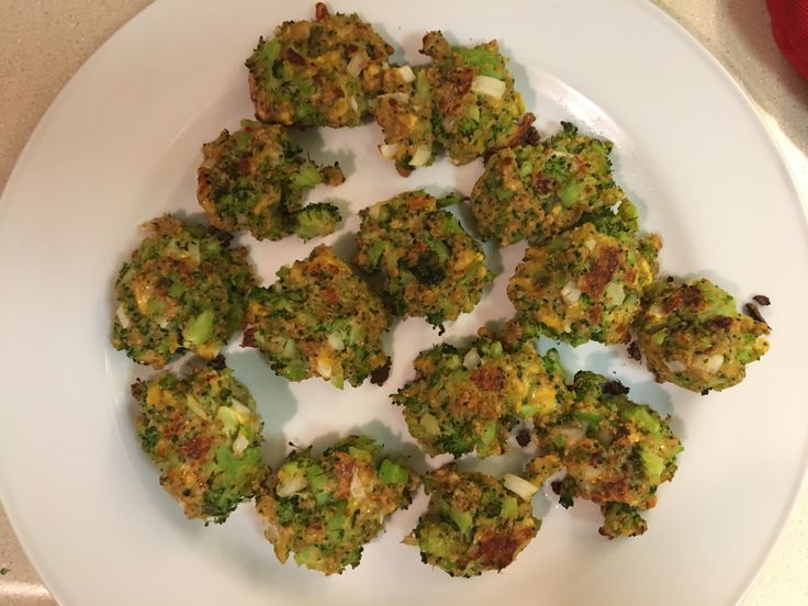 broccoli florets are arranged on a white plate, ready to be eaten