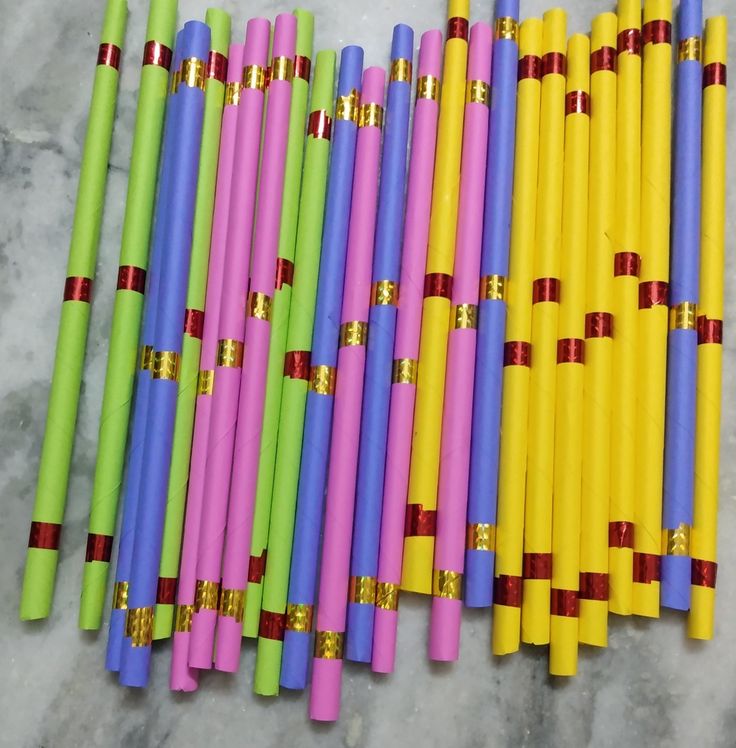 many colored sticks lined up next to each other on a marble surface with gold trimmings