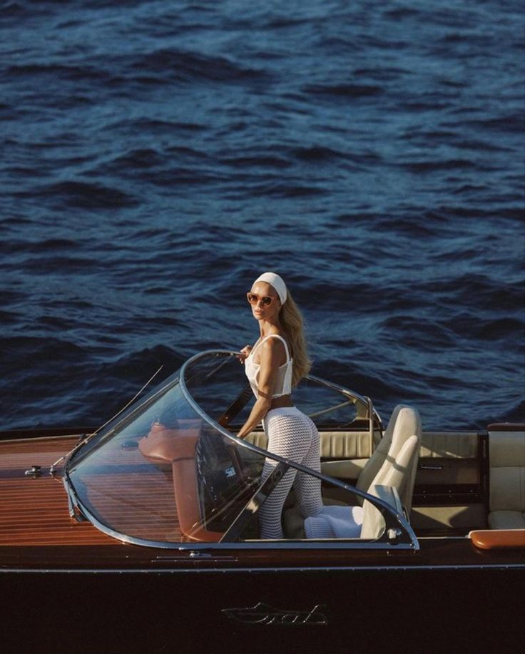 a woman is sitting in a boat on the water