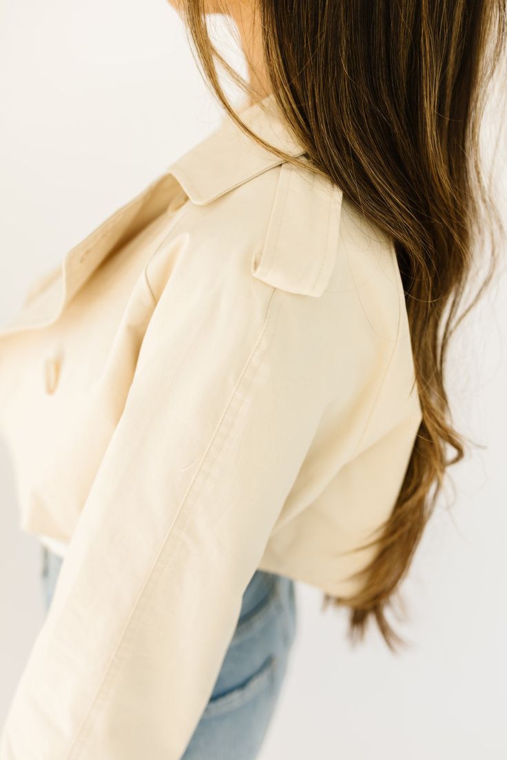 this cropped trench coat-esque jacket will take any spring outfit to the next level. it features chic tortoise shell buttons + has the most perfect cropped silhouette. whether you throw it on to elevate a basic outfit or use it as the focal point of your ensemble, it’s guaranteed to get you allll the compliments. butter // lapel collar, buttons, cuffed sleeves paired with our lotti tank + sicily distressed denim model is 5'7" + wearing a small measurements are approximate + taken while laying fl Chic Cropped Fall Outerwear, Chic Cropped Jacket For Fall Day Out, Chic Cropped Outerwear For Work, Trendy Double-breasted Cropped Jacket For Spring, Spring Casual Cropped Jacket With Double Button Closure, Trendy Collared Cropped Jacket For Spring, Chic Cropped Outerwear For Spring, Cropped Outerwear For Fall Day Out, Fitted Cropped Jacket With Double Button Closure For Spring