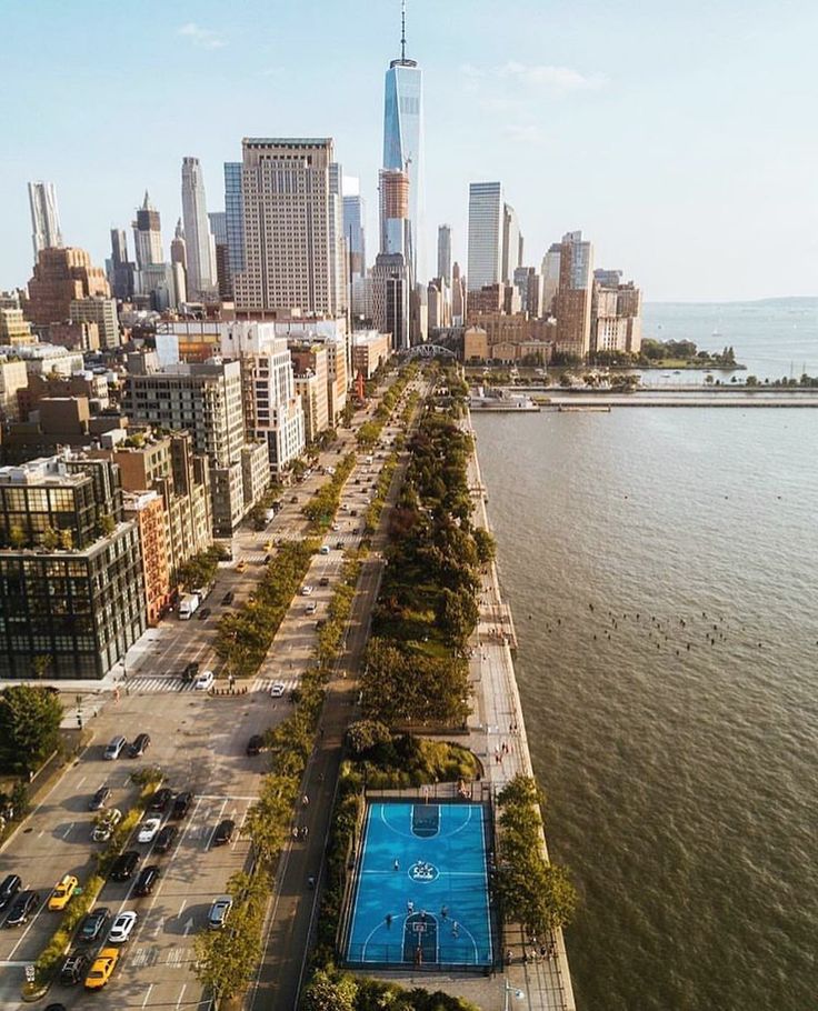 an aerial view of a city with tall buildings and a swimming pool in the foreground