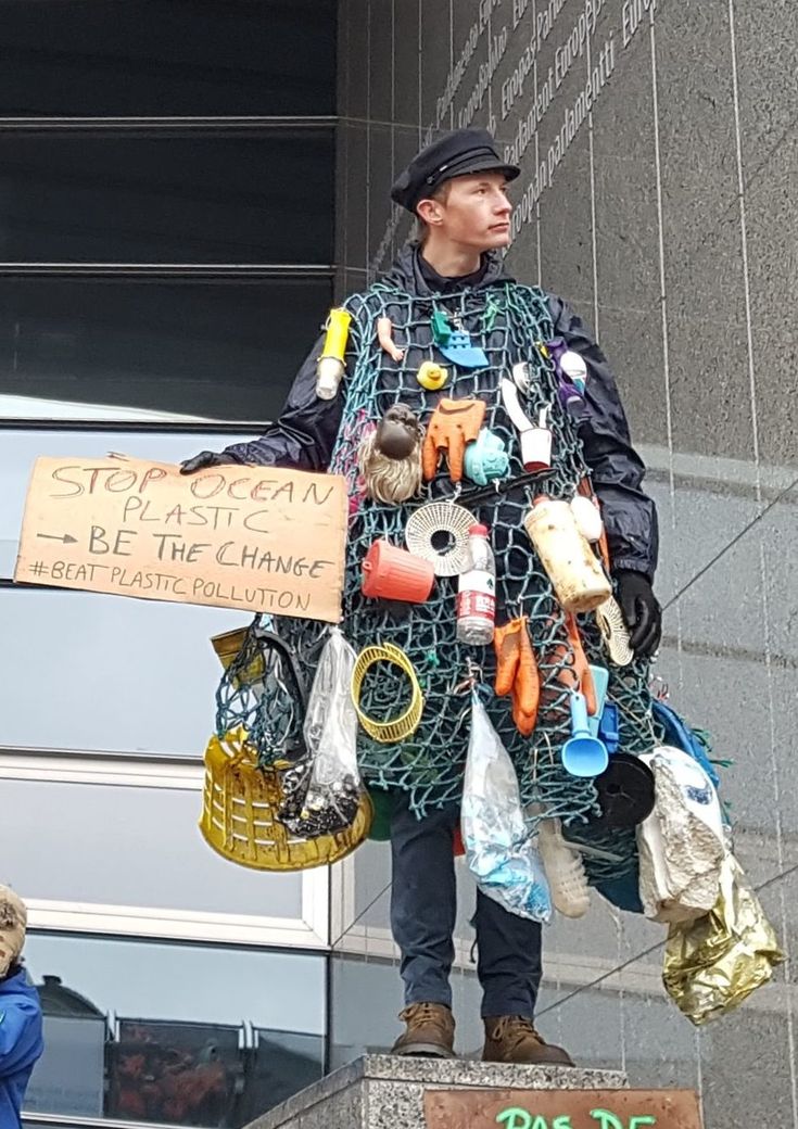 a man standing on top of a statue holding a sign that says stop racism, i've been the change