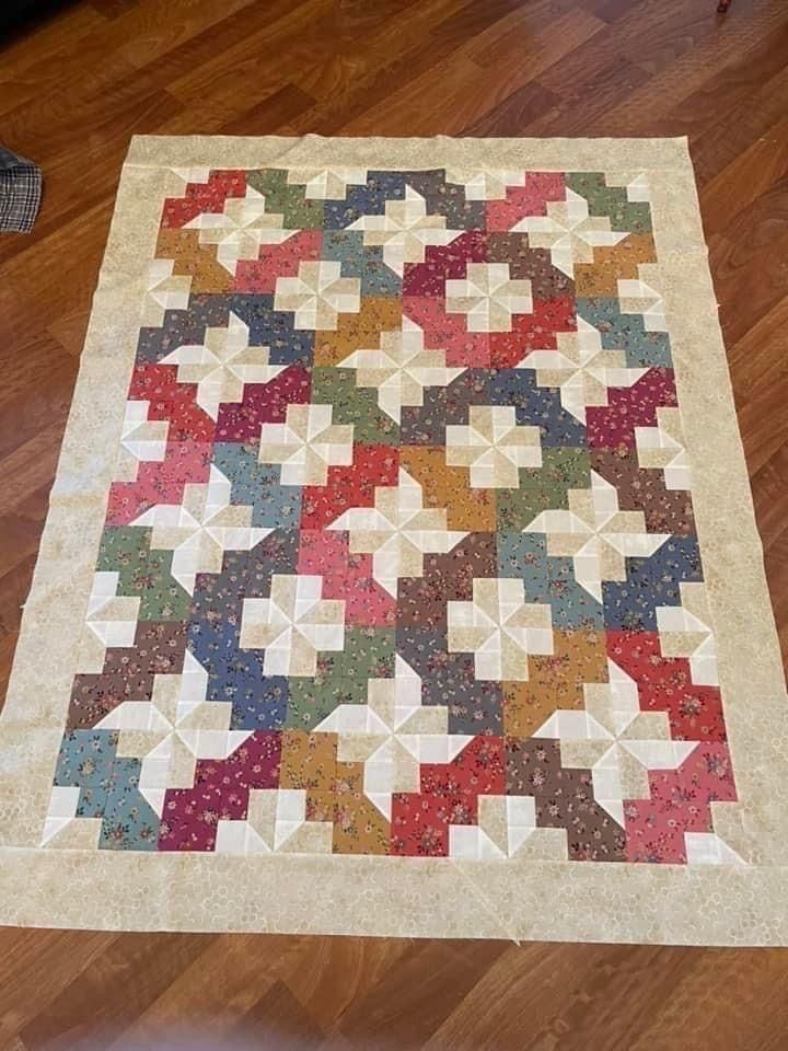 a multicolored quilt is laying on the floor