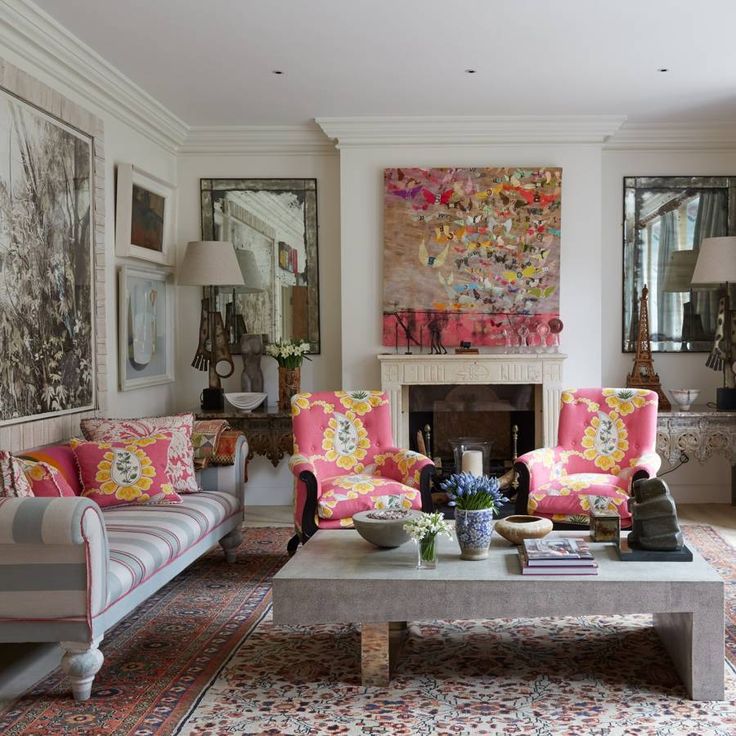 a woman sitting on a couch in a living room next to a table with flowers